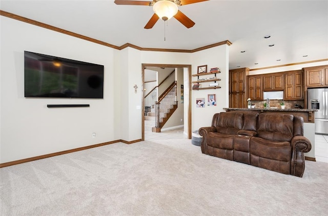 living room featuring ceiling fan, light colored carpet, and ornamental molding