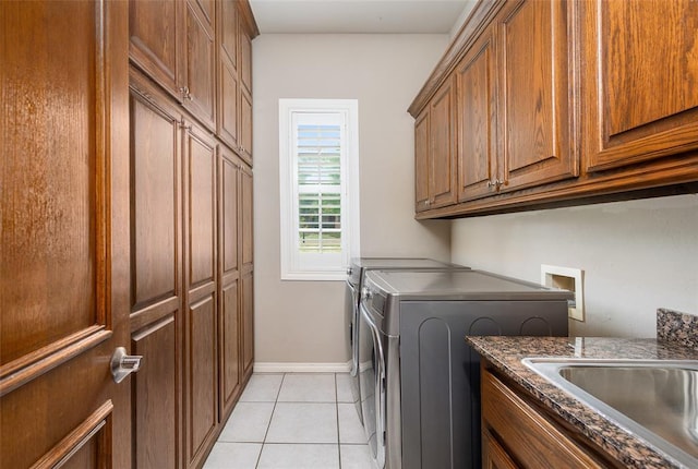 washroom with light tile patterned flooring, cabinets, sink, and washer and dryer