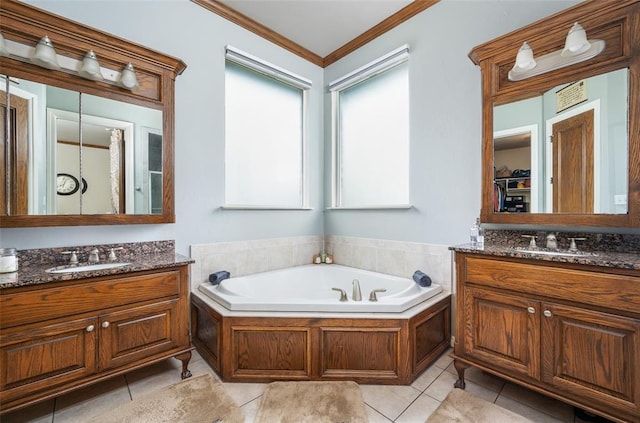 bathroom with tile patterned floors, ornamental molding, a bathtub, and vanity