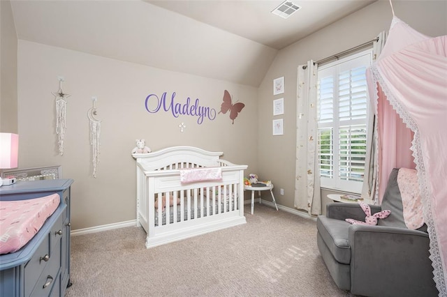 carpeted bedroom with a crib and vaulted ceiling