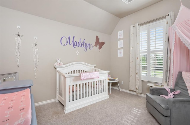 carpeted bedroom featuring vaulted ceiling and a nursery area