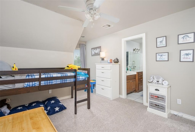 bedroom with light carpet, ensuite bath, lofted ceiling, and ceiling fan