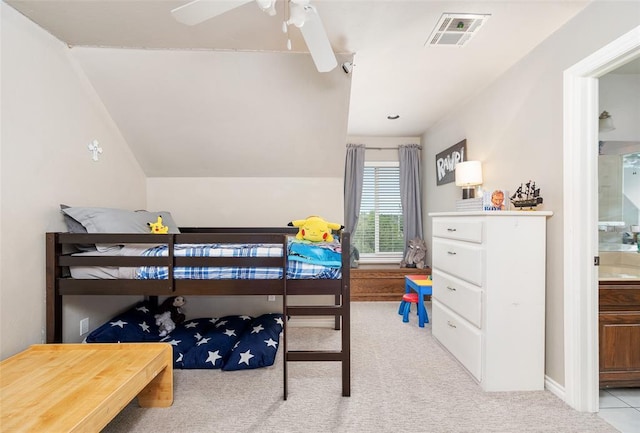 bedroom featuring ceiling fan, lofted ceiling, ensuite bathroom, and light carpet