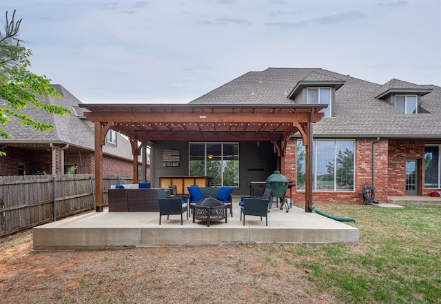 rear view of house featuring a lawn, an outdoor living space with a fire pit, and a patio