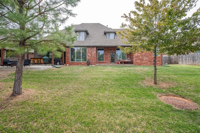 rear view of house featuring a yard and a patio area