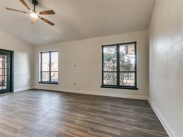 spare room with ceiling fan, vaulted ceiling, baseboards, and wood finished floors