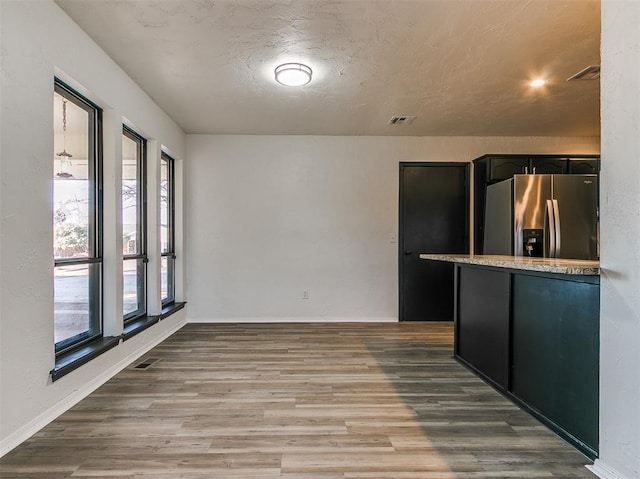 interior space featuring baseboards, visible vents, and wood finished floors