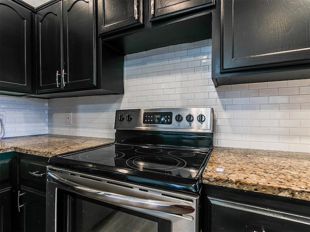 kitchen featuring dark cabinets, tasteful backsplash, and stainless steel electric stove