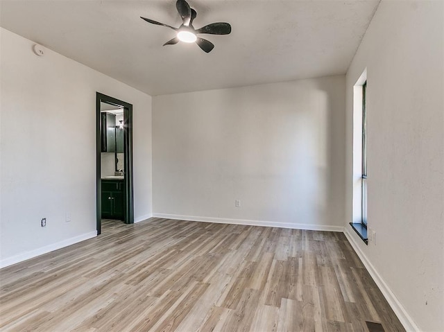 empty room with plenty of natural light, ceiling fan, baseboards, and wood finished floors