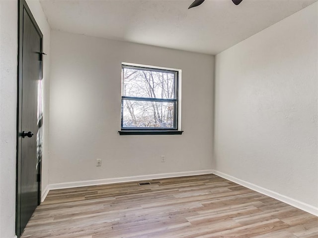 unfurnished bedroom with visible vents, light wood finished floors, a ceiling fan, and baseboards