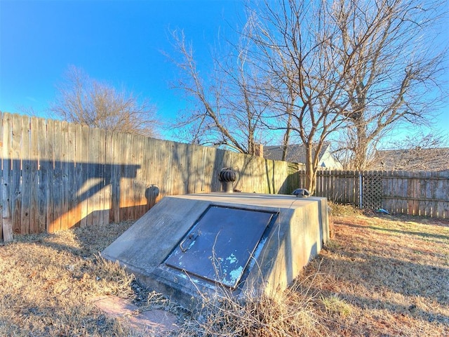 entry to storm shelter featuring a fenced backyard