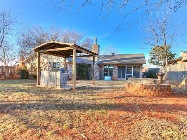 back of house with a fenced backyard, a chimney, and a patio