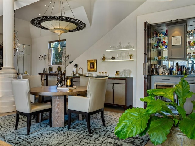 dining space featuring ornate columns and lofted ceiling