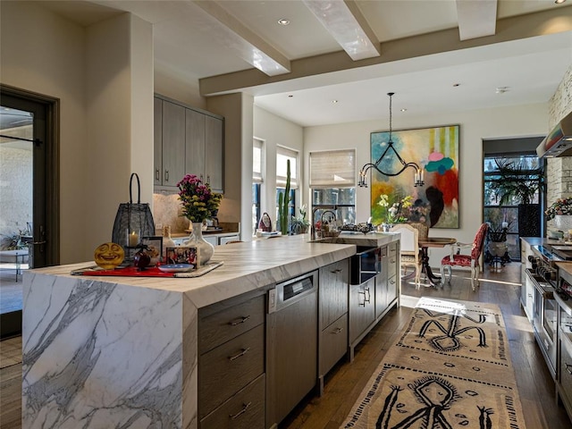 kitchen with pendant lighting, beamed ceiling, sink, a kitchen island with sink, and stainless steel dishwasher