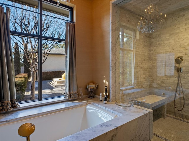 bathroom with an inviting chandelier and a tub