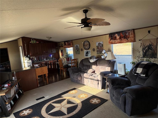 carpeted living room with vaulted ceiling, ornamental molding, a healthy amount of sunlight, and ceiling fan