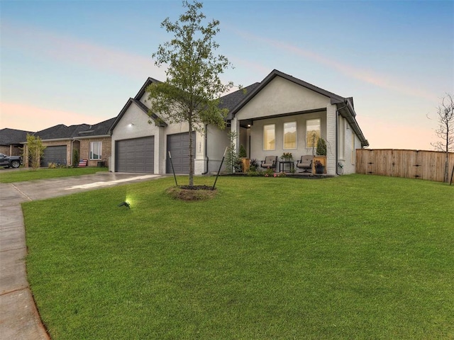 ranch-style home featuring a garage and a lawn