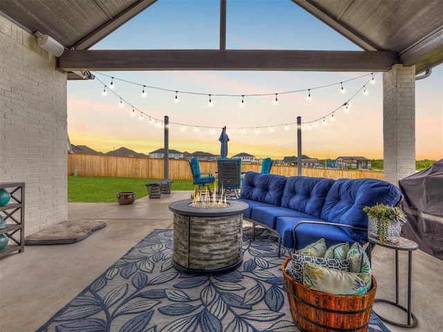 patio terrace at dusk with an outdoor living space with a fire pit