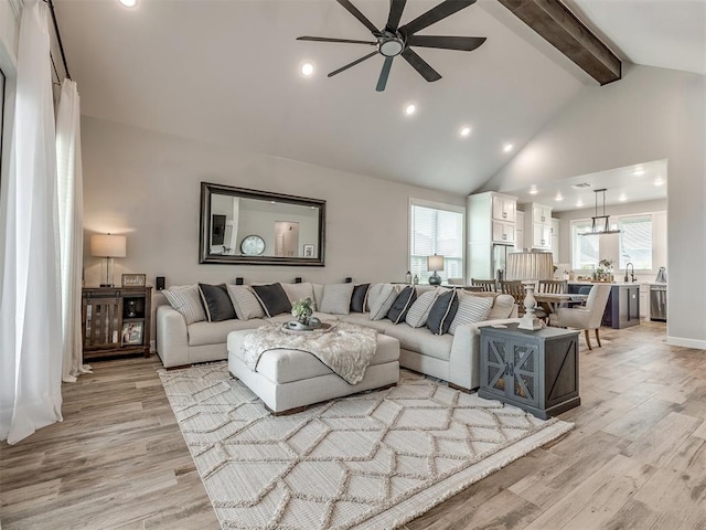 living room featuring beamed ceiling, ceiling fan, high vaulted ceiling, and light wood-type flooring