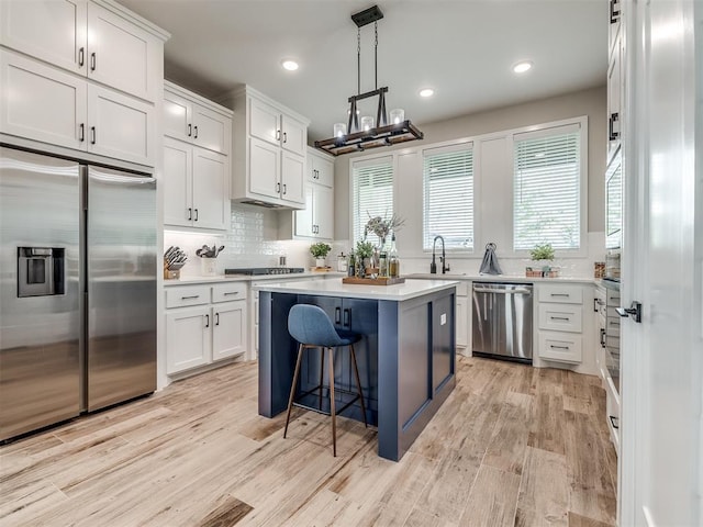 kitchen featuring appliances with stainless steel finishes, a kitchen island, and white cabinets