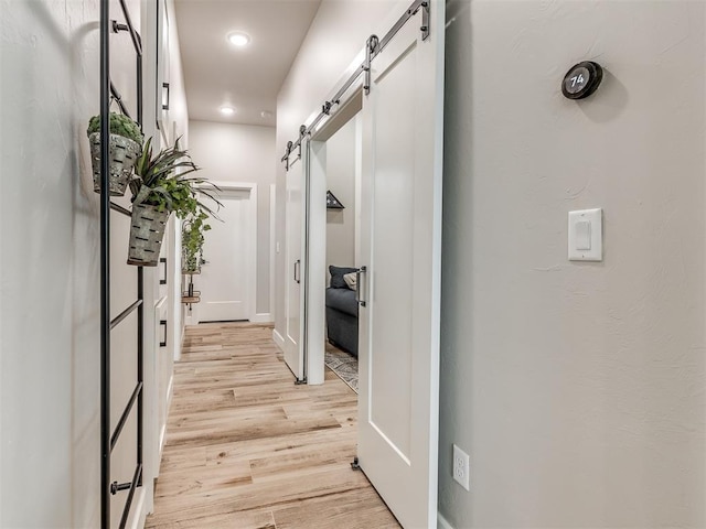 hall featuring a barn door and light wood-type flooring