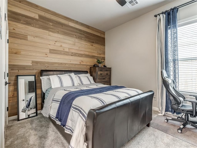 bedroom featuring wooden walls and carpet