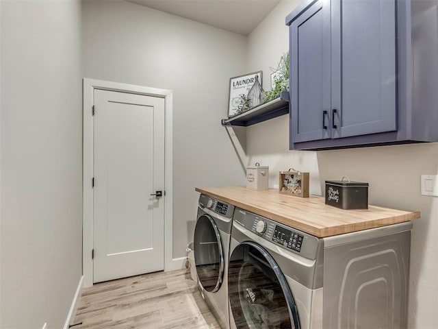 washroom with cabinets, light wood-type flooring, and independent washer and dryer