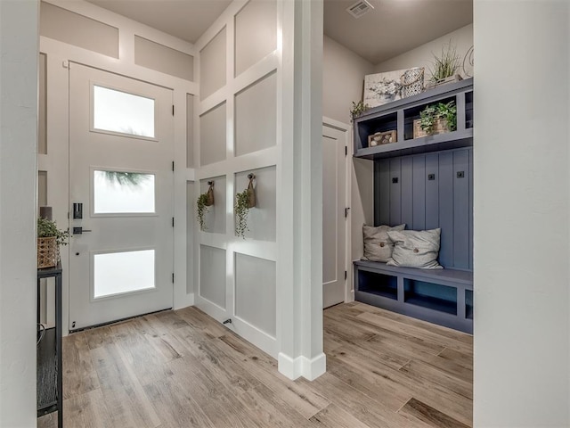 mudroom with light hardwood / wood-style flooring and a high ceiling