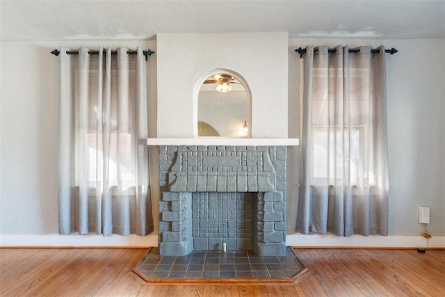 unfurnished living room with hardwood / wood-style floors and a tile fireplace