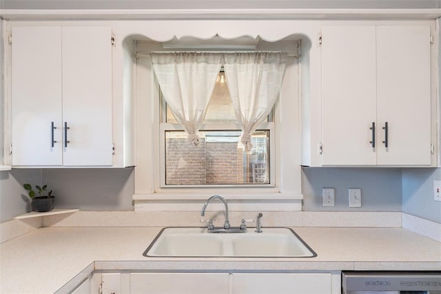 kitchen with sink, white cabinets, and white dishwasher