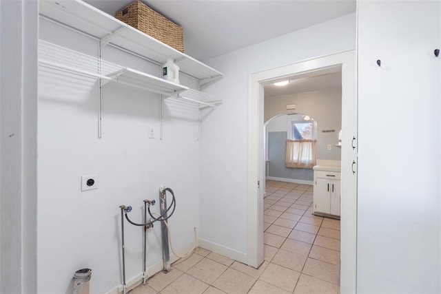 clothes washing area with hookup for an electric dryer, washer hookup, and light tile patterned floors