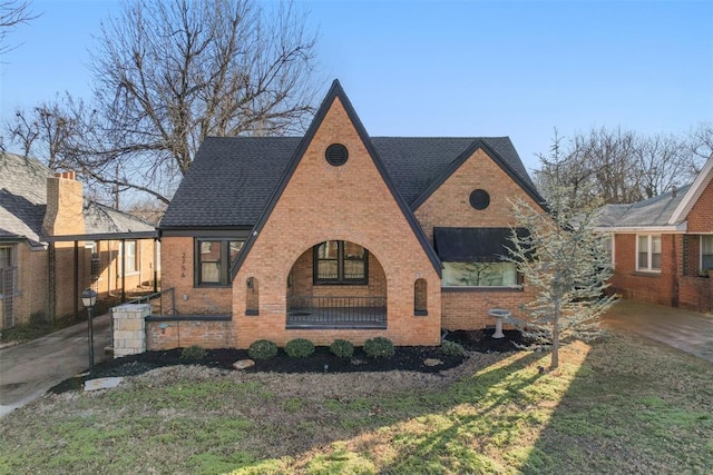 english style home featuring a front lawn