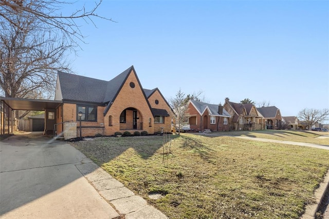 tudor house featuring a front yard and a carport