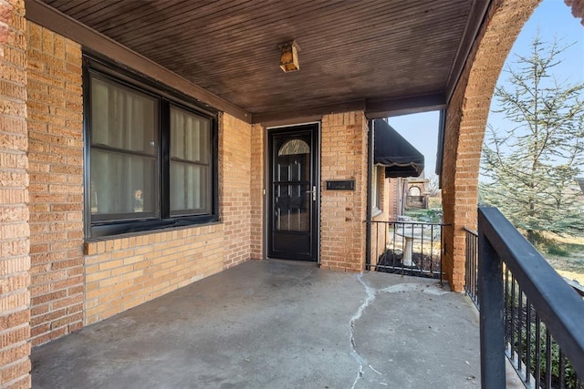 view of exterior entry featuring brick siding