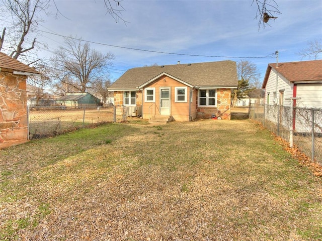 back of property featuring a yard and central AC