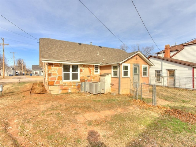 rear view of house with a lawn and central air condition unit