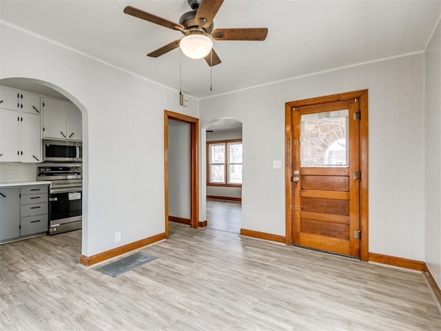 interior space with crown molding, ceiling fan, and light hardwood / wood-style flooring
