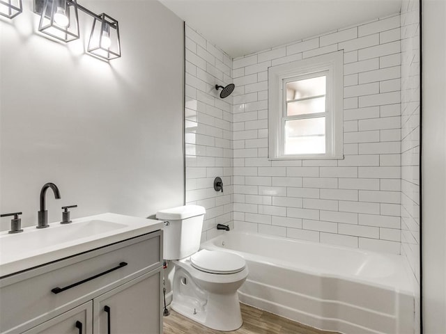 full bathroom featuring vanity, hardwood / wood-style floors, toilet, and tiled shower / bath