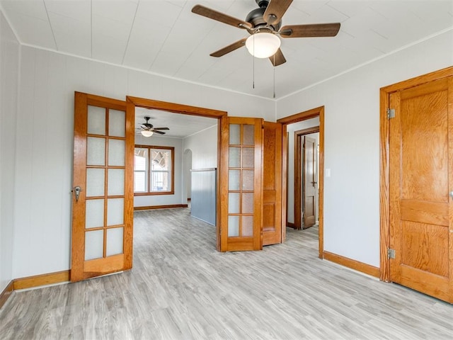 empty room with light hardwood / wood-style flooring, ceiling fan, and french doors