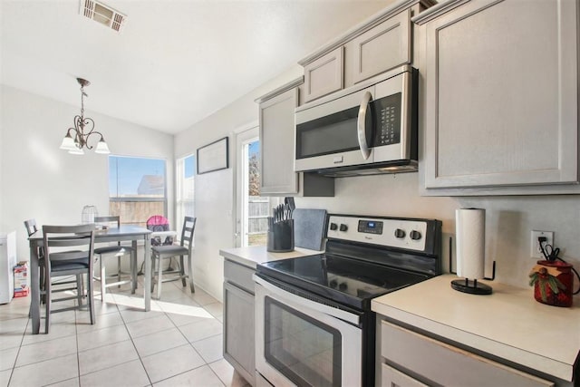 kitchen with hanging light fixtures, appliances with stainless steel finishes, and gray cabinetry