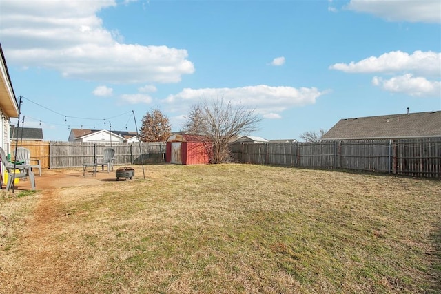 view of yard with a storage shed and an outdoor fire pit