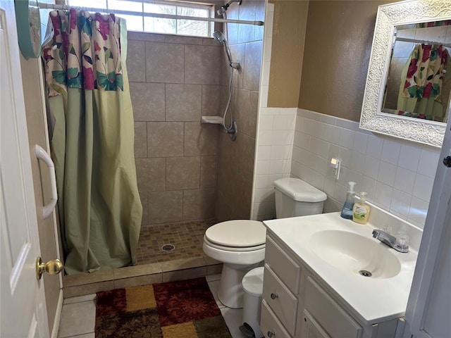 full bath with tile walls, toilet, a shower stall, vanity, and tile patterned flooring