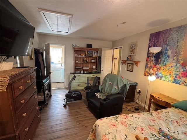 bedroom with attic access, washer / dryer, dark wood finished floors, and baseboards