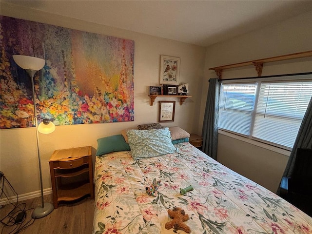 bedroom featuring baseboards and wood finished floors