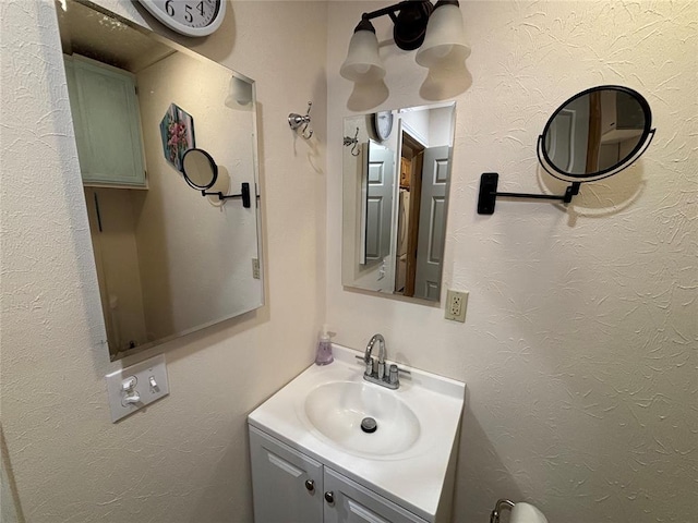 bathroom with a textured wall and vanity