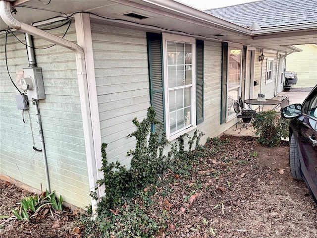 view of side of property featuring a shingled roof