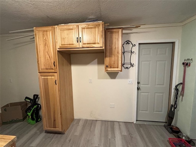 laundry room with a textured ceiling and wood finished floors