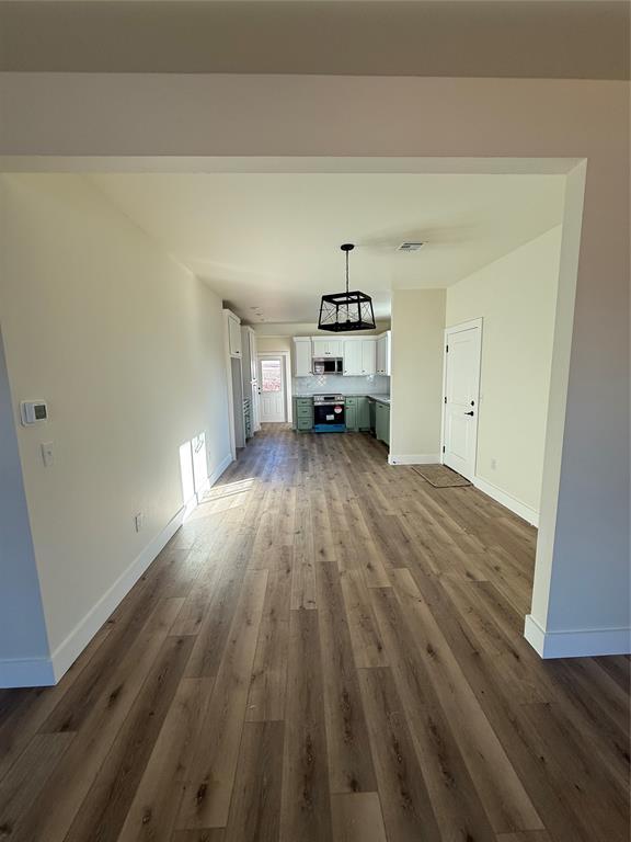 unfurnished living room with dark hardwood / wood-style flooring