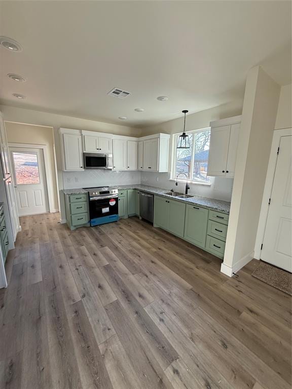 kitchen featuring sink, stainless steel appliances, white cabinets, and green cabinetry