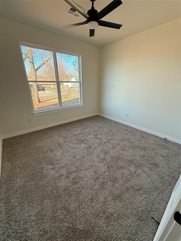 carpeted spare room with ceiling fan